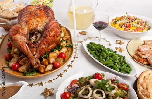 Christmas dinner table with stuffed roast turkey and assorted side dishes