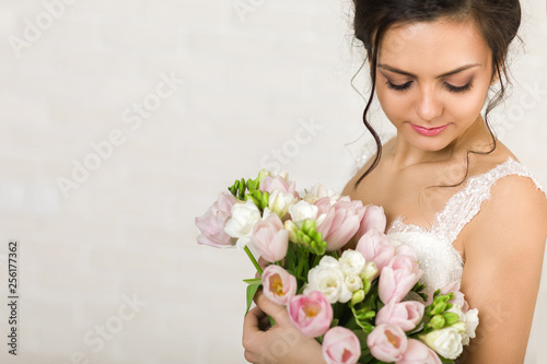Portrait of beautiful bride with wedding bouquet of pink tulips