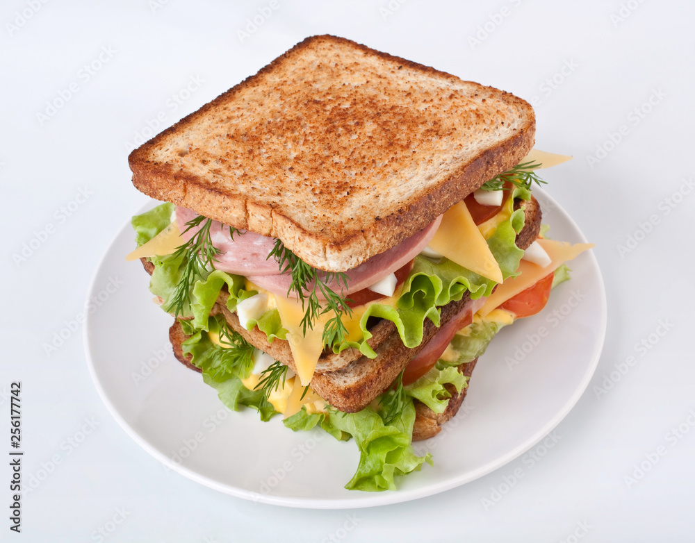 Big healthy toasted bread, meat, lettuce and cheese sandwich on a white background Big healthy toasted bread, meat, lettuce and cheese sandwich on a white background