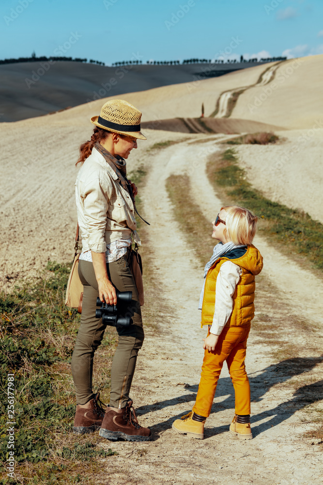 Naklejka premium happy mother and daughter with binoculars looking at each other