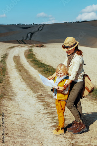 mother and child on summer hiking in Tuscany looking at map