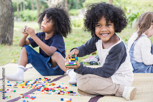 Canvastavla Little boy playing with colorful plastic blocks toy with his friends