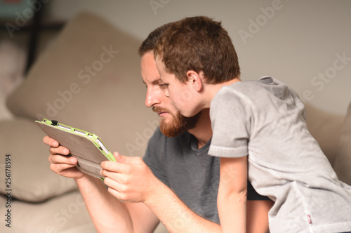 father and child looking at a tablet