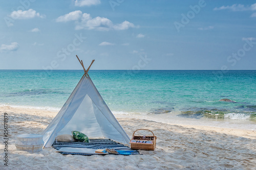 Fototapeta Naklejka Na Ścianę i Meble -  romantic white picnic tent on white sand beach with crystal clear water and blue sky at background