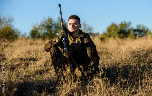 Rest for real man concept. Hunter with rifle relaxing in nature environment. Tired but satisfied. End of season. Hunter enjoy nature view. Hunting hobby leisure. Hunter satisfied with catch relaxing