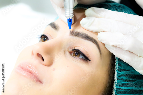 Wallpaper Mural Cosmetologist making permanent make up on eyebrows, tattoo procedure on young woman in beauty salon, extreme close up Torontodigital.ca