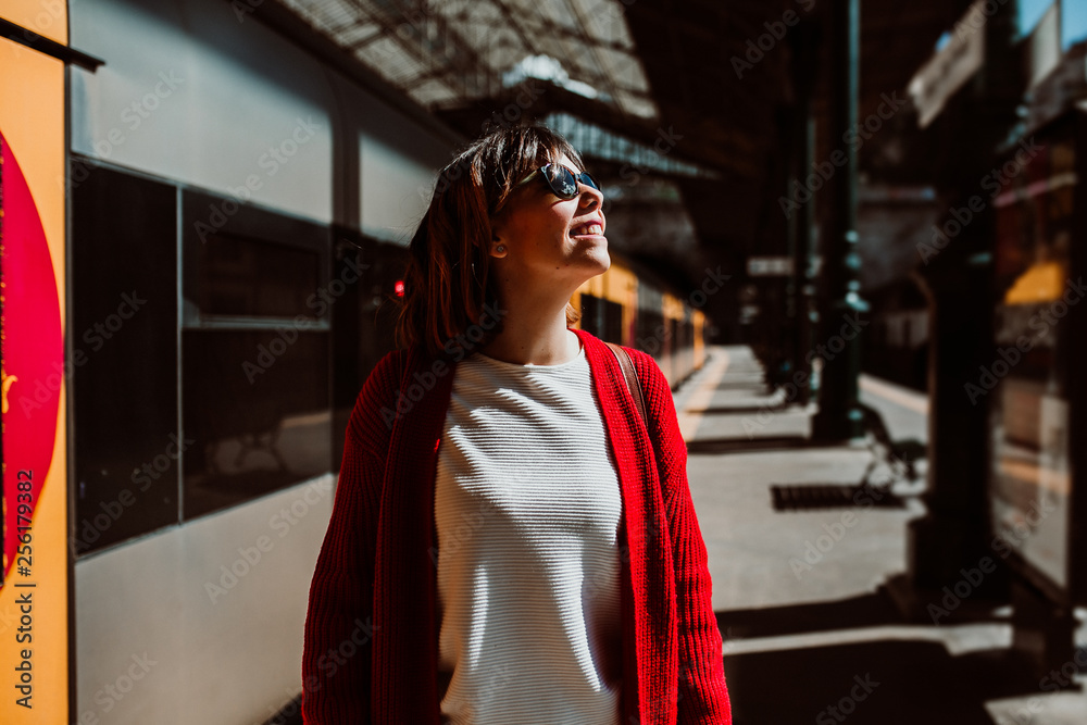 .Young woman with short hair and red jacket excited with her travel around europe. About to take a train at the train station of oporto, portugal. Lifestyle .Young woman with short hair and red jacket excited with her travel around europe. About to take a train at the train station of oporto, portugal. Lifestyle