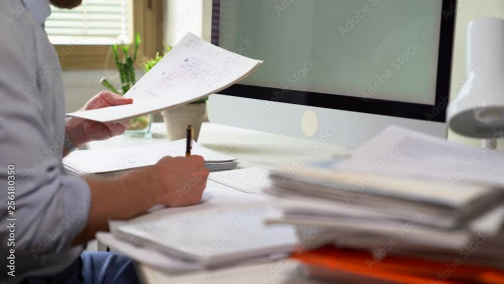 Businessman reading paperwork at desk in office. Office clerk work with documents and typing keyboard on desktop computer. 4K