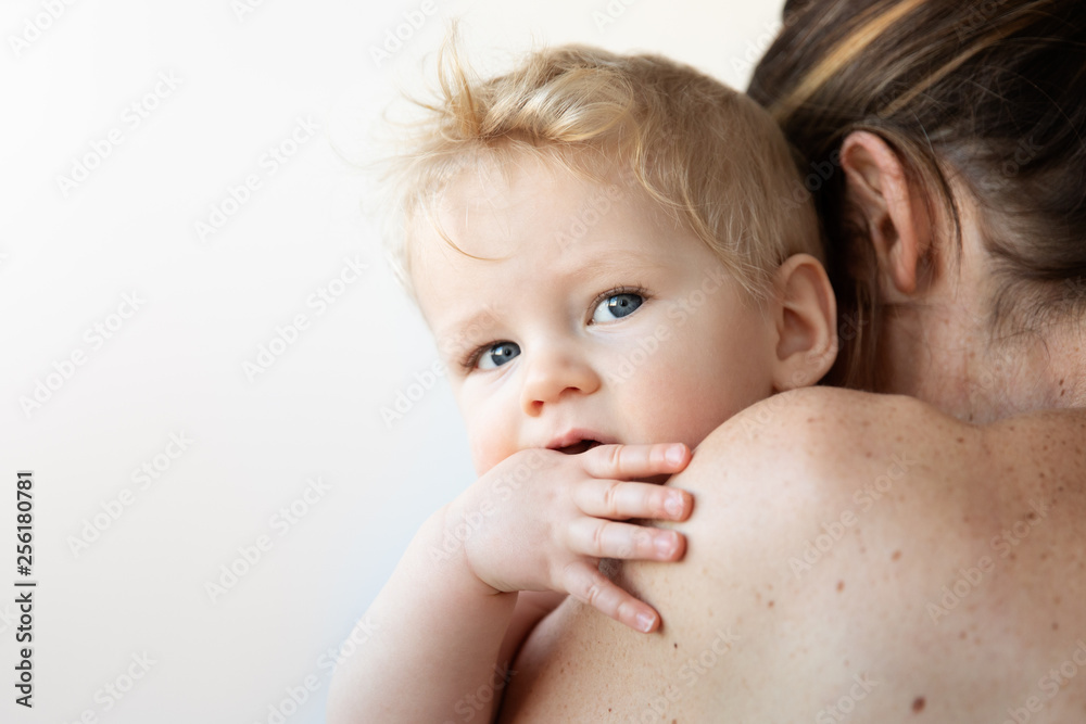 Mother holding baby looking over shoulder Mother holding baby looking over shoulder