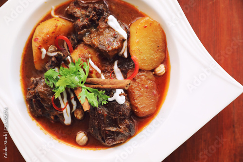 Beef massaman curry with rice and salad on wooden background , Thai food