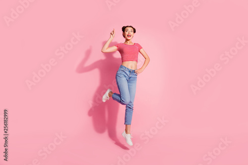 Full length body size photo beautiful she her lady jump high recommend buy buyer new product show look empty space wear casual jeans denim striped red white t-shirt sit floor isolated pink background © deagreez