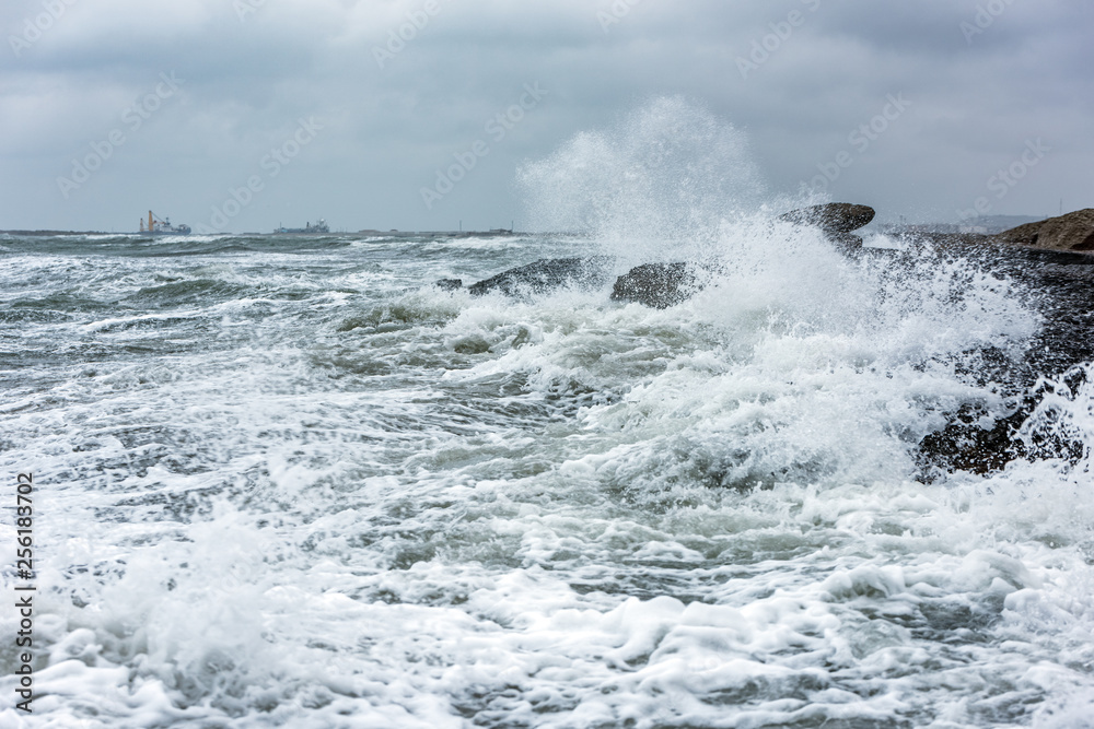 Splash of huge waves on a rocky shore