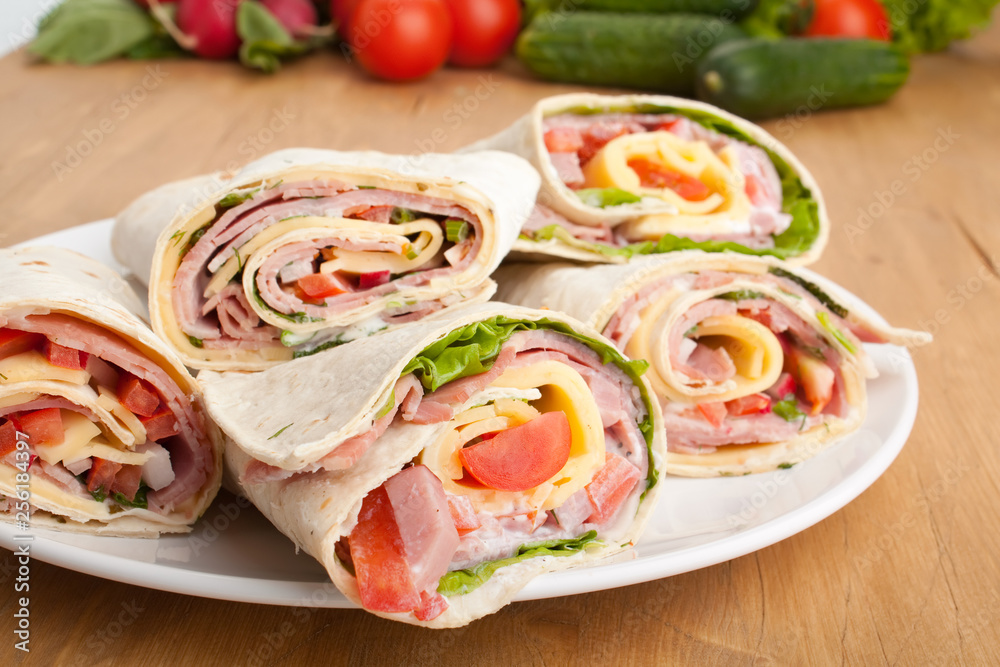 wrapped tortilla sandwich rolls cut in half and ingredients