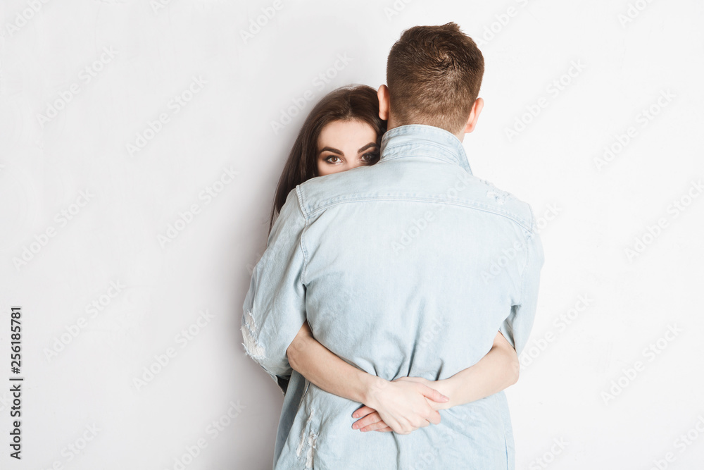 woman looking at camera and embracing man on white woman looking at camera and embracing man on white