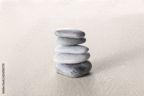 zen stone concept, grey stones piled on the sand with copy space for your text