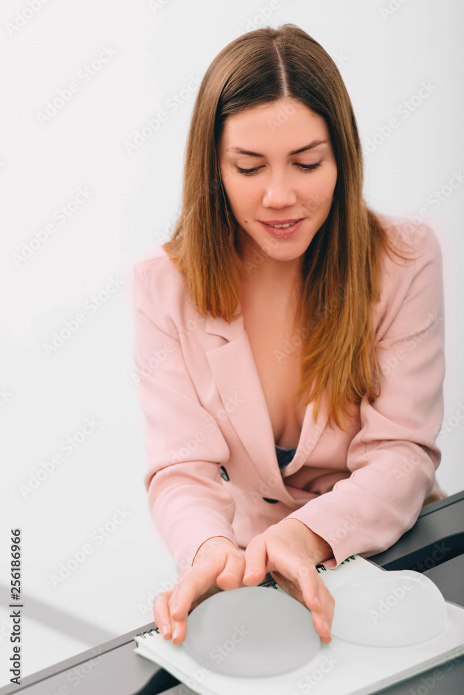 Young woman during the consultation and selection of breast silicone implants. breast augmentation