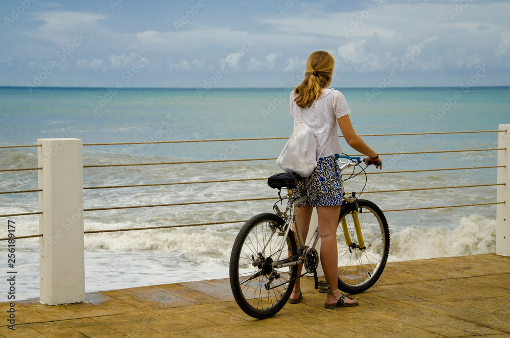 girl on a bike on the pier. - obrazy, fototapety, plakaty 
