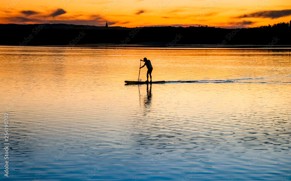 stand-up-paddling at sunset in the lake, concept relaxing sport