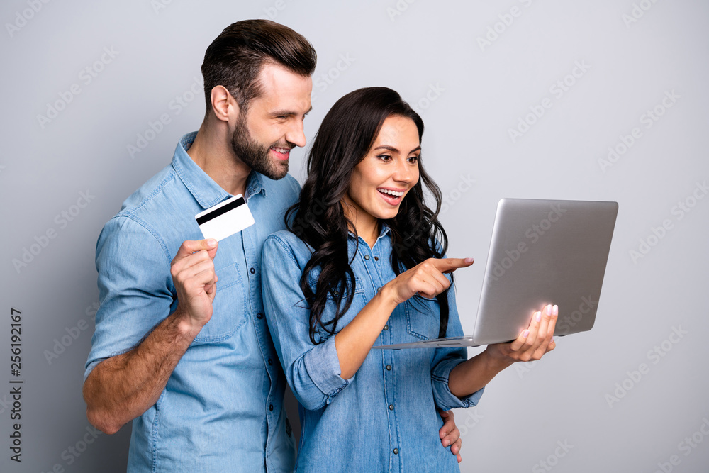 Close up photo of impressed cheerful handsome guy lady want purchase goods bargains black friday addicted consumerism pointing finger laptop holding hand dressed denim shirts argent background Close up photo of impressed cheerful handsome guy lady want purchase goods bargains black friday addicted consumerism pointing finger laptop holding hand dressed denim shirts argent background