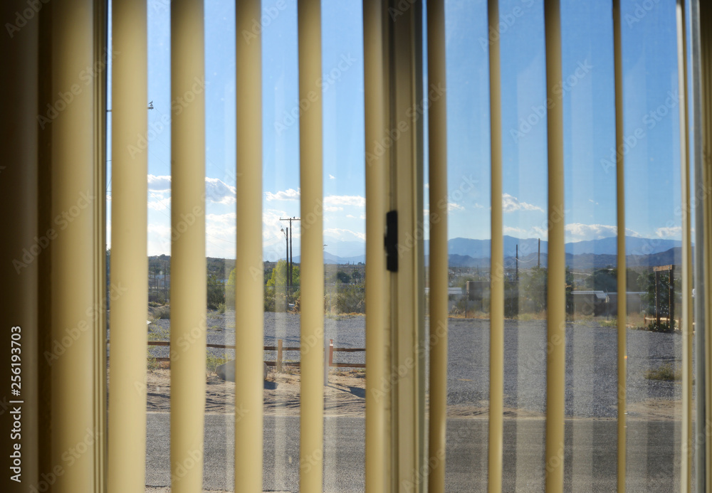 Vew through a curtain in a motel room on a suburban village in the american desert Vew through a curtain in a motel room on a suburban village in the american desert