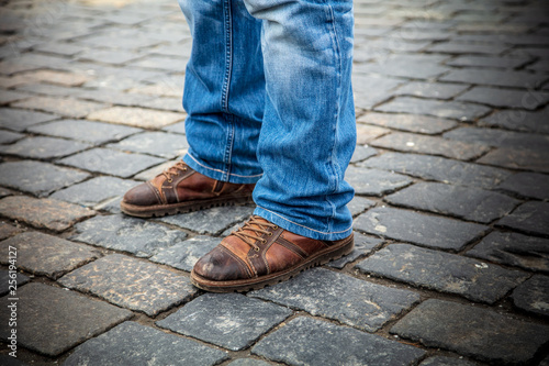 Legs of men in jeans on the pavement