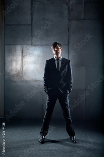 Confident young man standing with hands in pockets