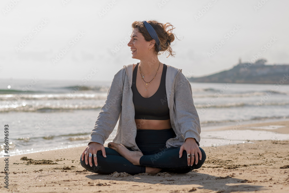 Fototapeta premium chica meditando en la orilla del mar 