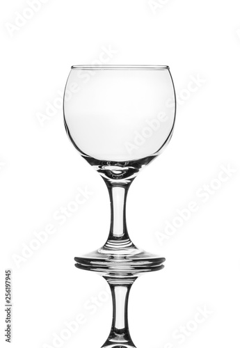A single empty wine glass isolated on a white background with reflection. High contrast black and white, black line lighting.