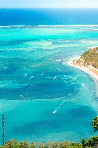 Beautiful view of a tropical beach with crystal clear water full of people windsurfing, from the mountain in le Le Morne Brabant, Mauritius © evoks24