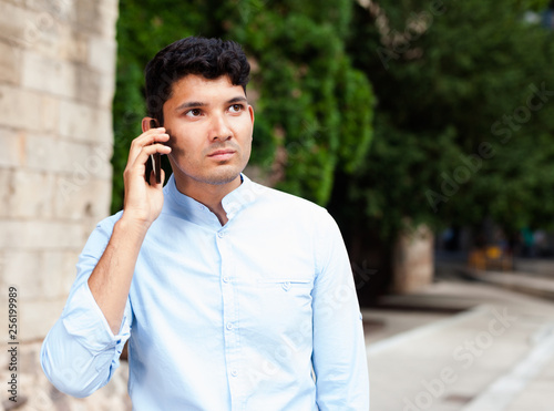 modern guy walks in city and communicates on smartphone photo