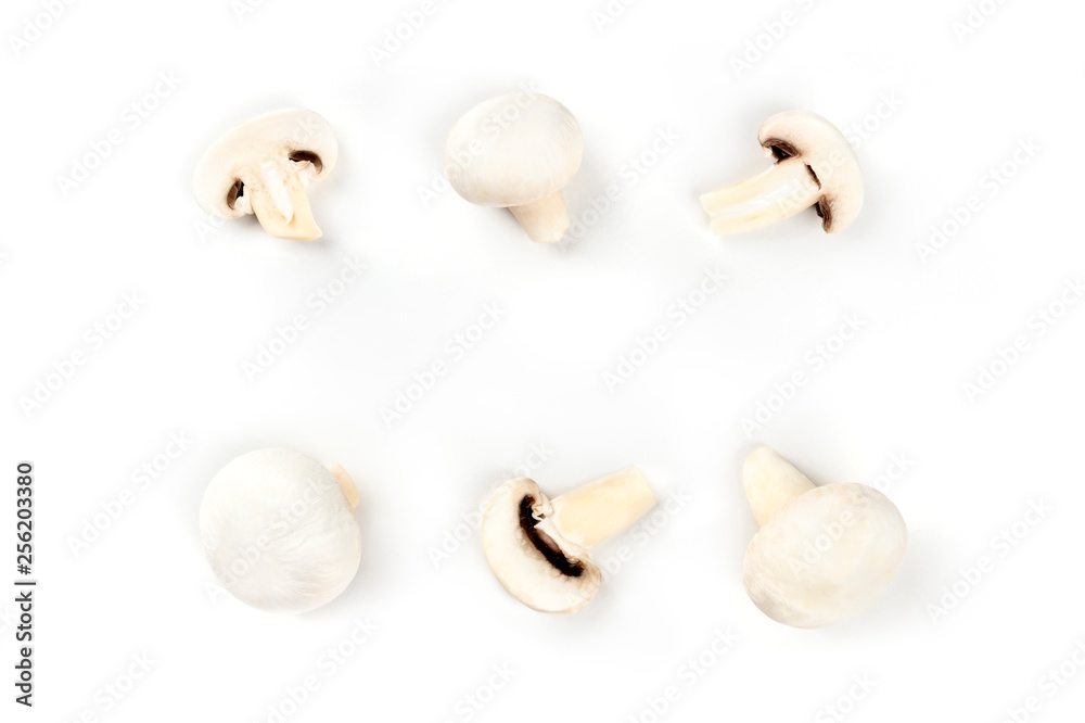 Champignon mushrooms, whole and sliced, shot from above on a white background, forming a frame with copy space Champignon mushrooms, whole and sliced, shot from above on a white background, forming a frame with copy space