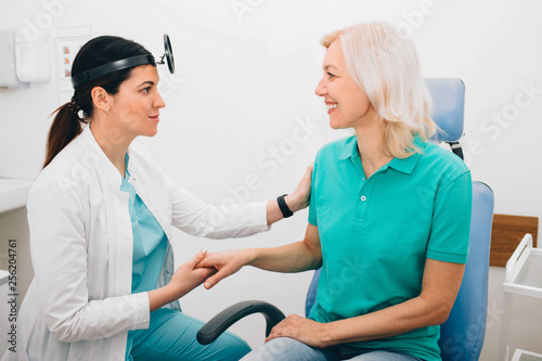 Doctor holding a patients hand in comfort and smiling. Medical care and support