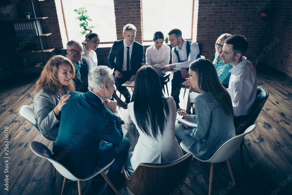 Obraz premium Nice classy elegant stylish attractive focused concentrated specialists sitting on chairs discussing financial corporate conference at modern industrial loft interior work place space