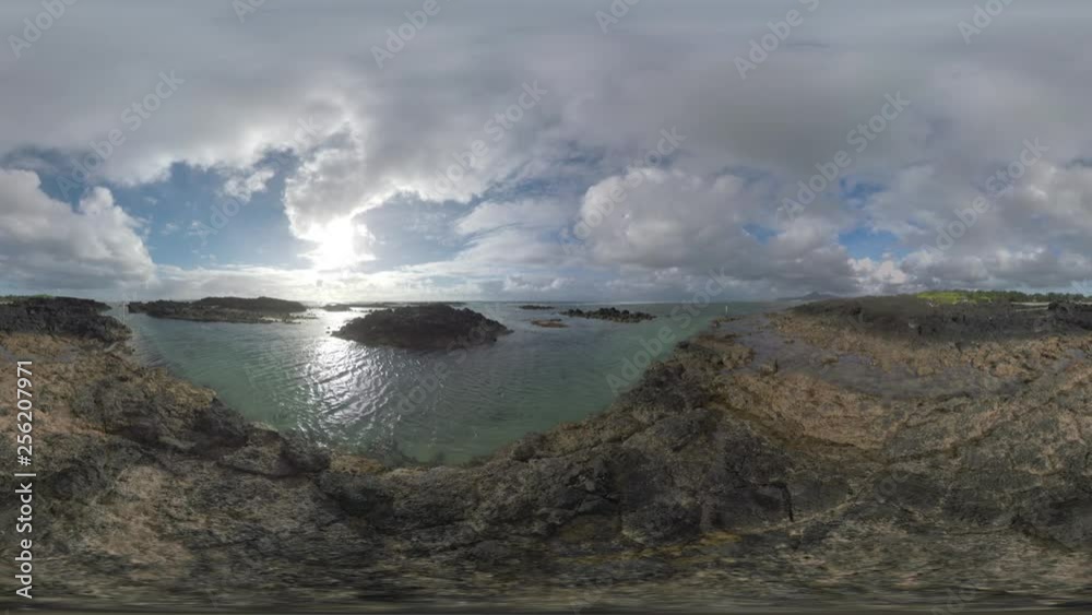 360 VR video. Waterscape and landscape of Mauritius. Ocean shallow water and black rocks on the coast, clouds sailing over the island 360 VR video. Waterscape and landscape of Mauritius. Ocean shallow water and black rocks on the coast, clouds sailing over the island