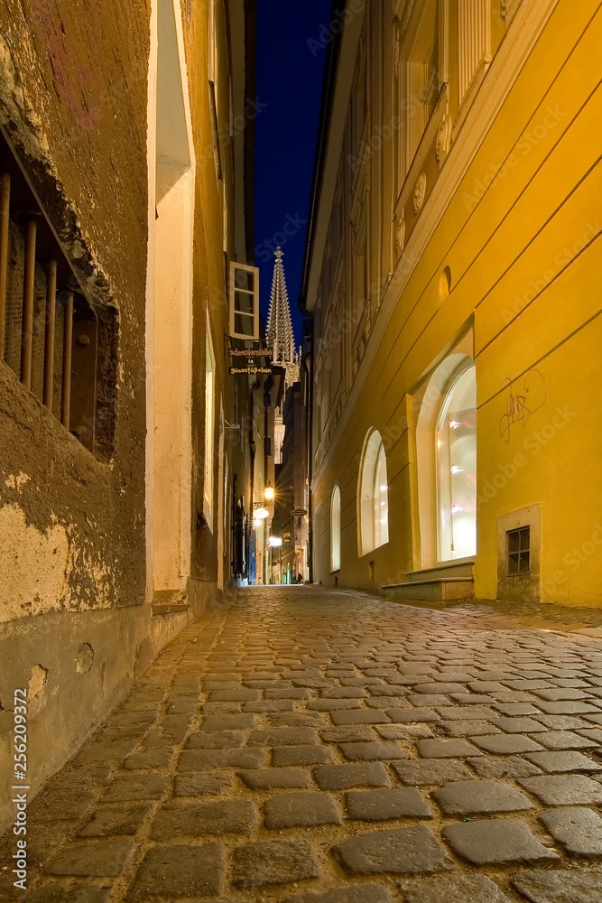 Gasse in Regensburg mit Domturm im Hintergrund zur blauen Stunde