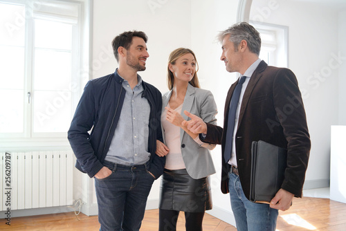 Couple with real-estate agent visiting light contemporary house