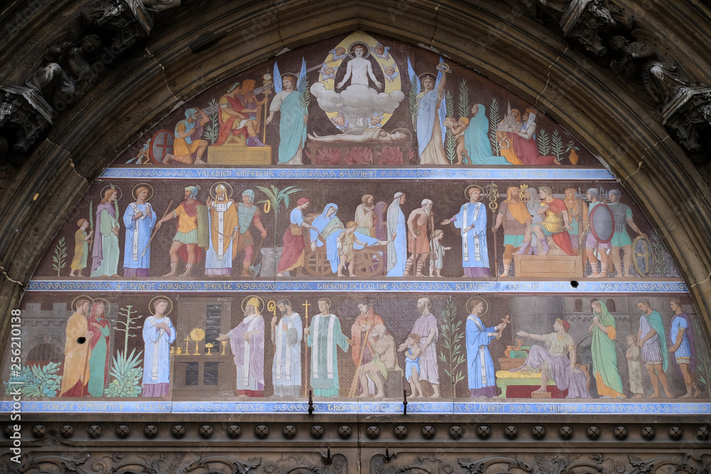 Fototapeta premium PARIS, FRANCE - JANUARY 07: Scenes from the life of Saint Laurent, Central Portal - Tympanum of the Saint Laurent Church, Paris, France on January 07, 2018.