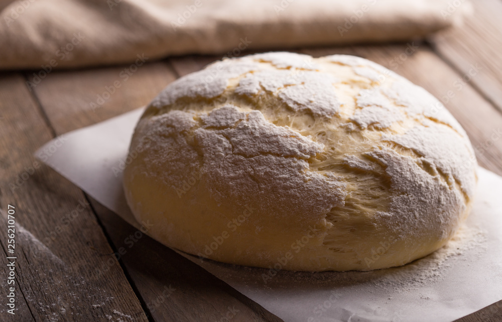 Dough and ingredients for it - eggs flour yeast on brown wooden background. Selective focus.