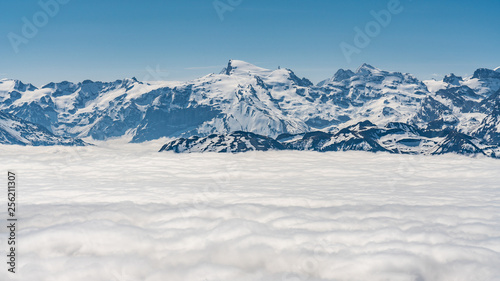 Switzerland, scenic panoramic view on snow Alps peaks above white clouds © AlehAlisevich