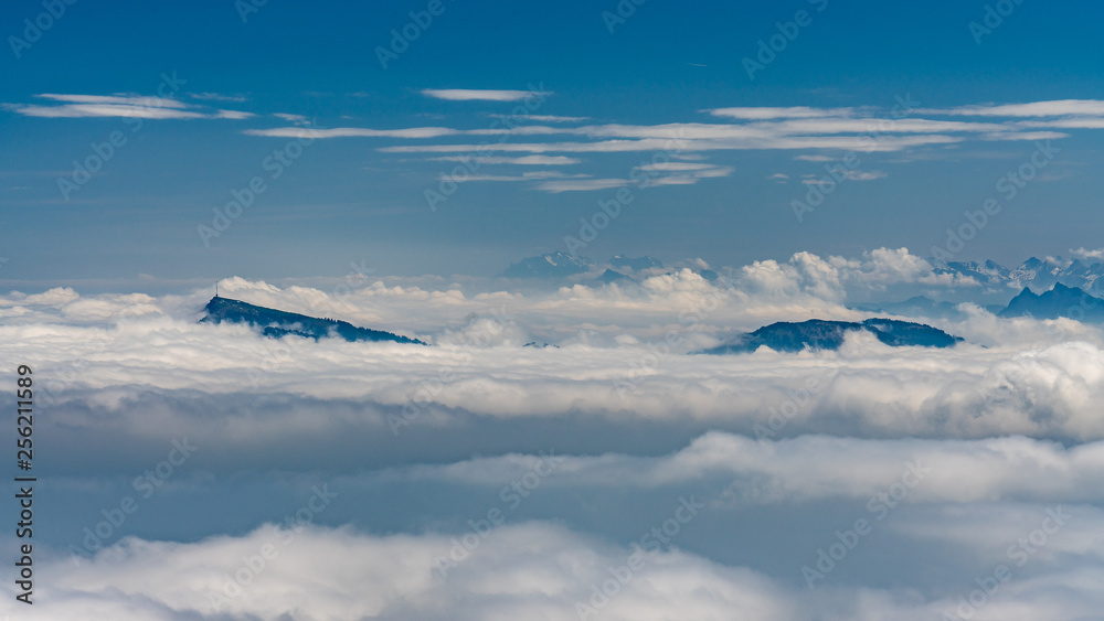 Fototapeta premium Switzerland, scenic panoramic view on snow Alps peaks above white clouds