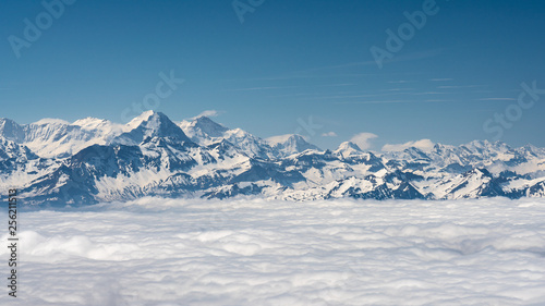 Switzerland  scenic panoramic view on snow Alps peaks above white clouds