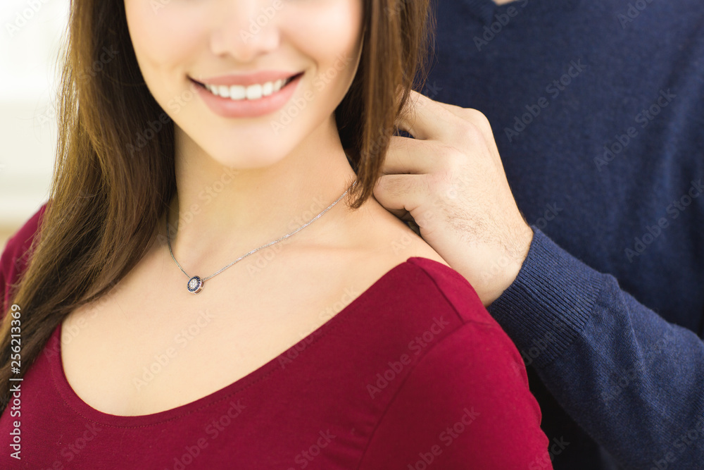 Young loving couple buying necklace at the jeweler’s Young loving couple buying necklace at the jeweler’s
