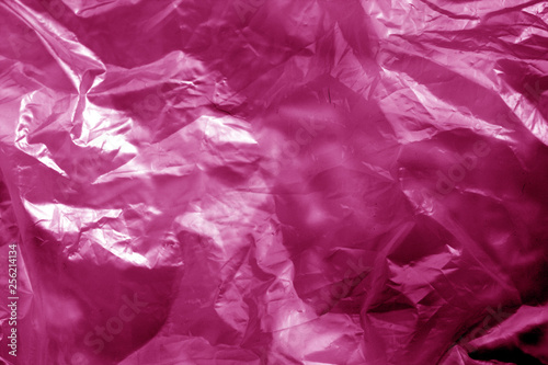 Crumpled transparent plastic  surface in pink tone. © pavelalexeev