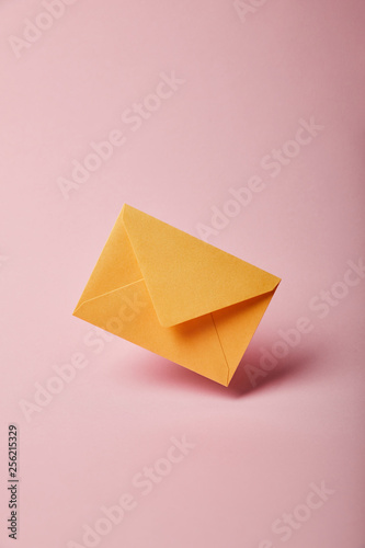 yellow and colorful envelope on pink background with copy space