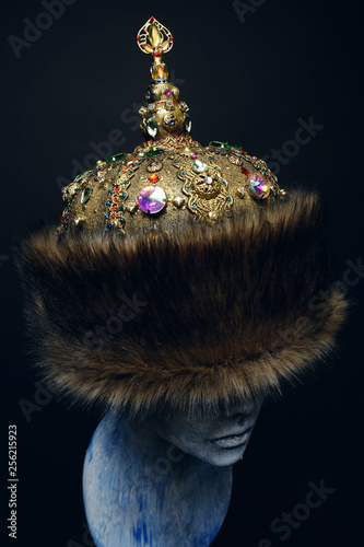 White head of mannequin in fur rich historical head-wear, dark studio background Fototapeta