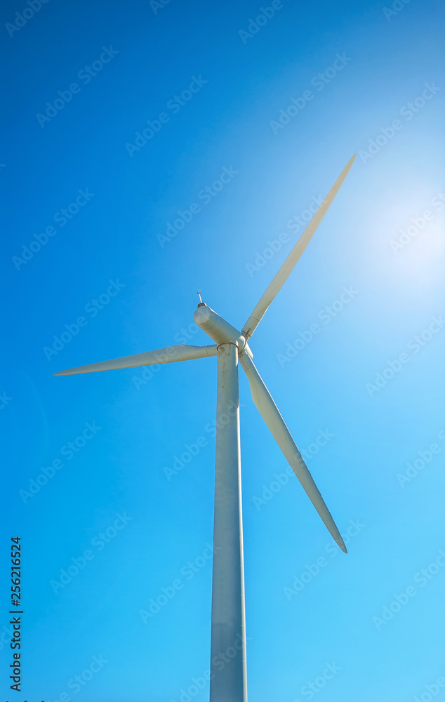 Big white propeller of wind power plant on blue sky background