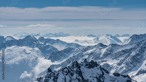 Switzerland, panorama view from Titlis mountain on Alps and mountains above white clouds