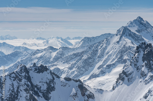 Switzerland, panorama view from Titlis mountain on Alps and mountains above white clouds