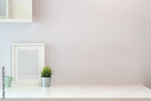 Mockup poster on white wooden desk space and copy space..