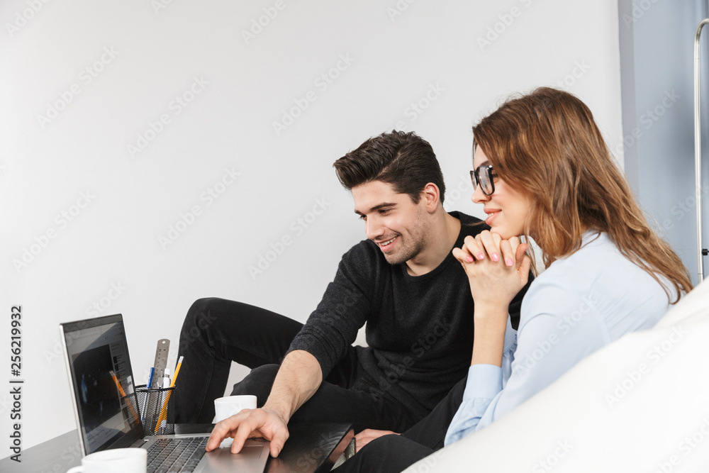 Cheerful young couple of colleagues working together Cheerful young couple of colleagues working together